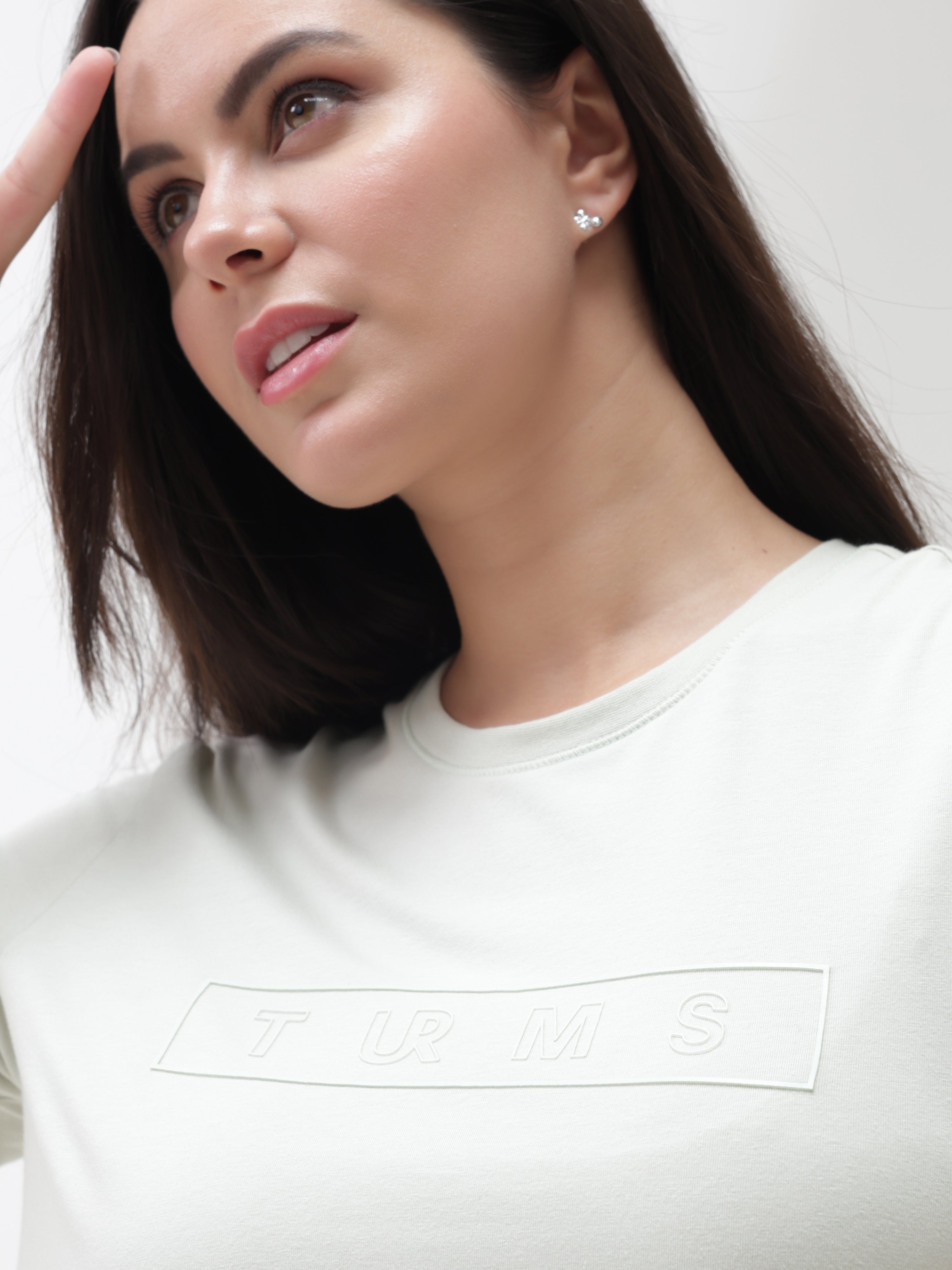 Woman wearing Lime Enigma Turms T-shirt with anti-stain and anti-odor properties, showcasing tailored fit and stretchable fabric.