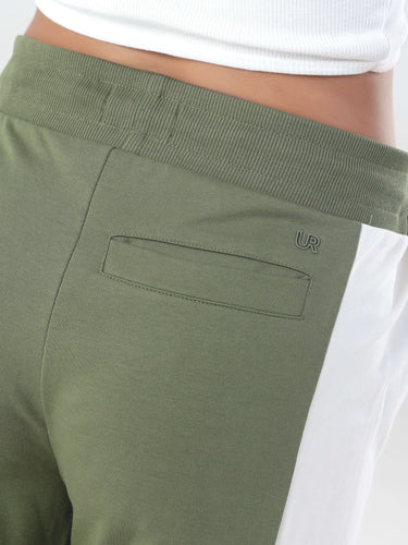 Close-up of olive green joggers with white side panel and logo detail, showcasing soft fabric and pocket design.