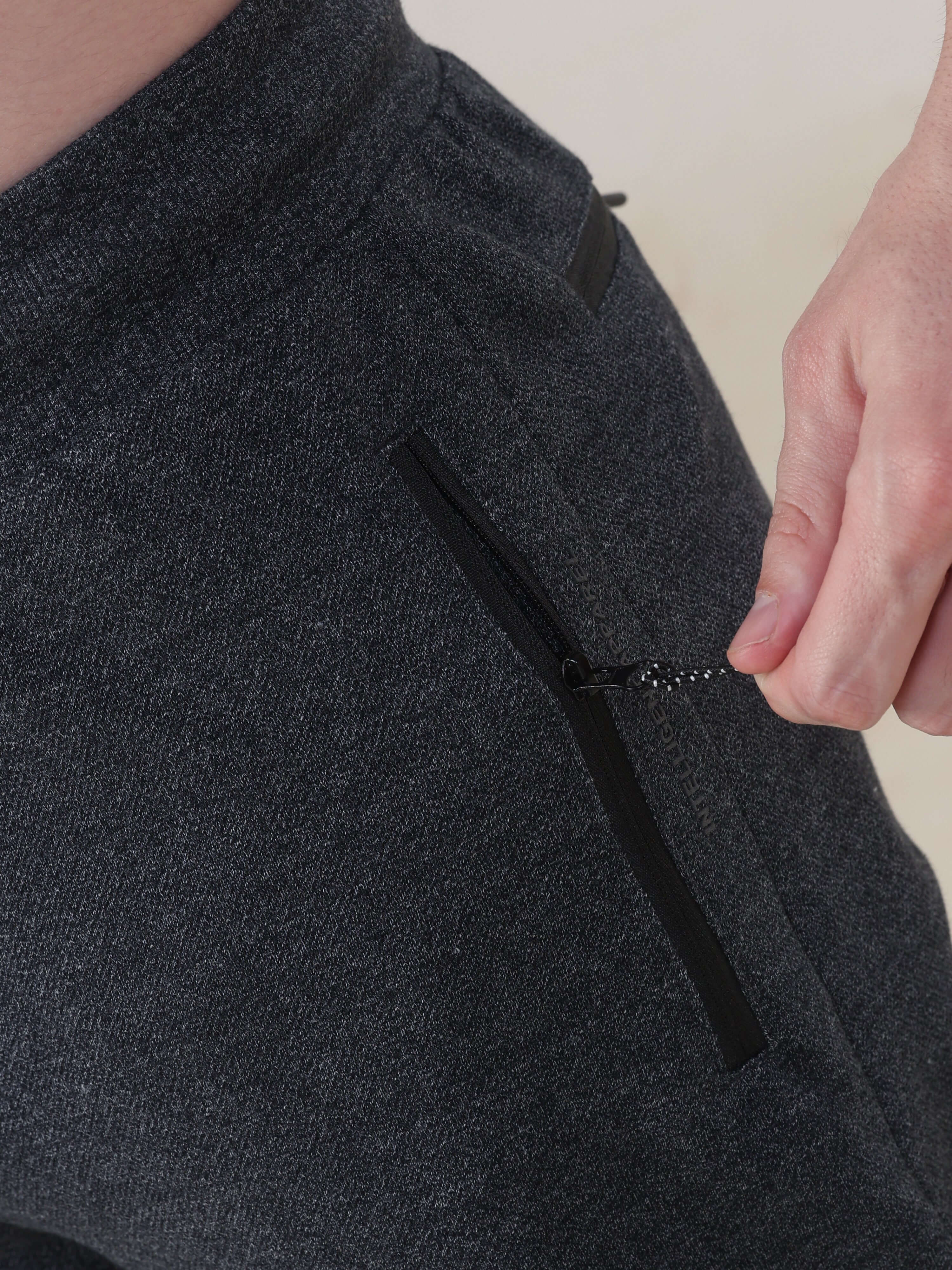 Close-up of men's navy jogger pants with zipper pocket detailing, showcasing premium material and stretchable design by Turms.