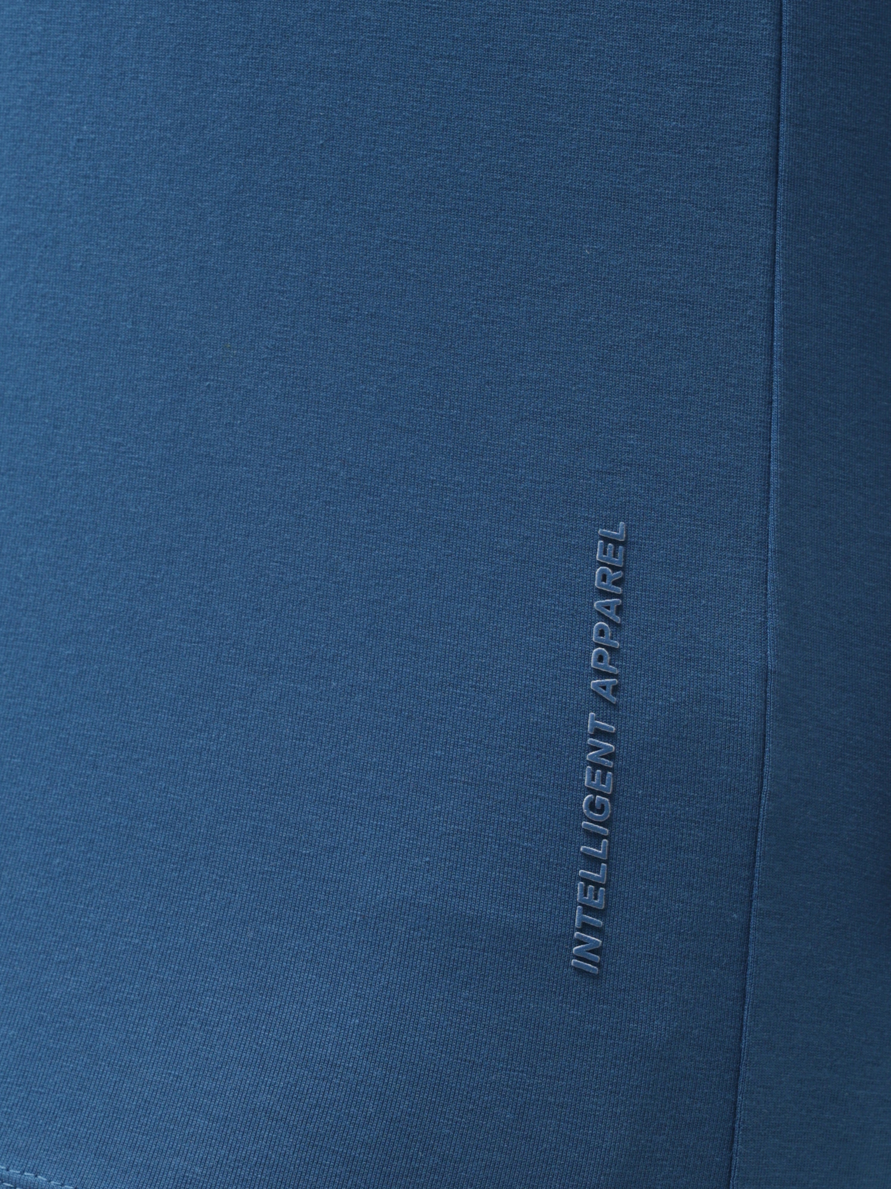 Close-up of Sea Blue Turms T-shirt fabric showcasing "Intelligent Apparel" text, highlighting its anti-stain, anti-odour, and stretchable properties