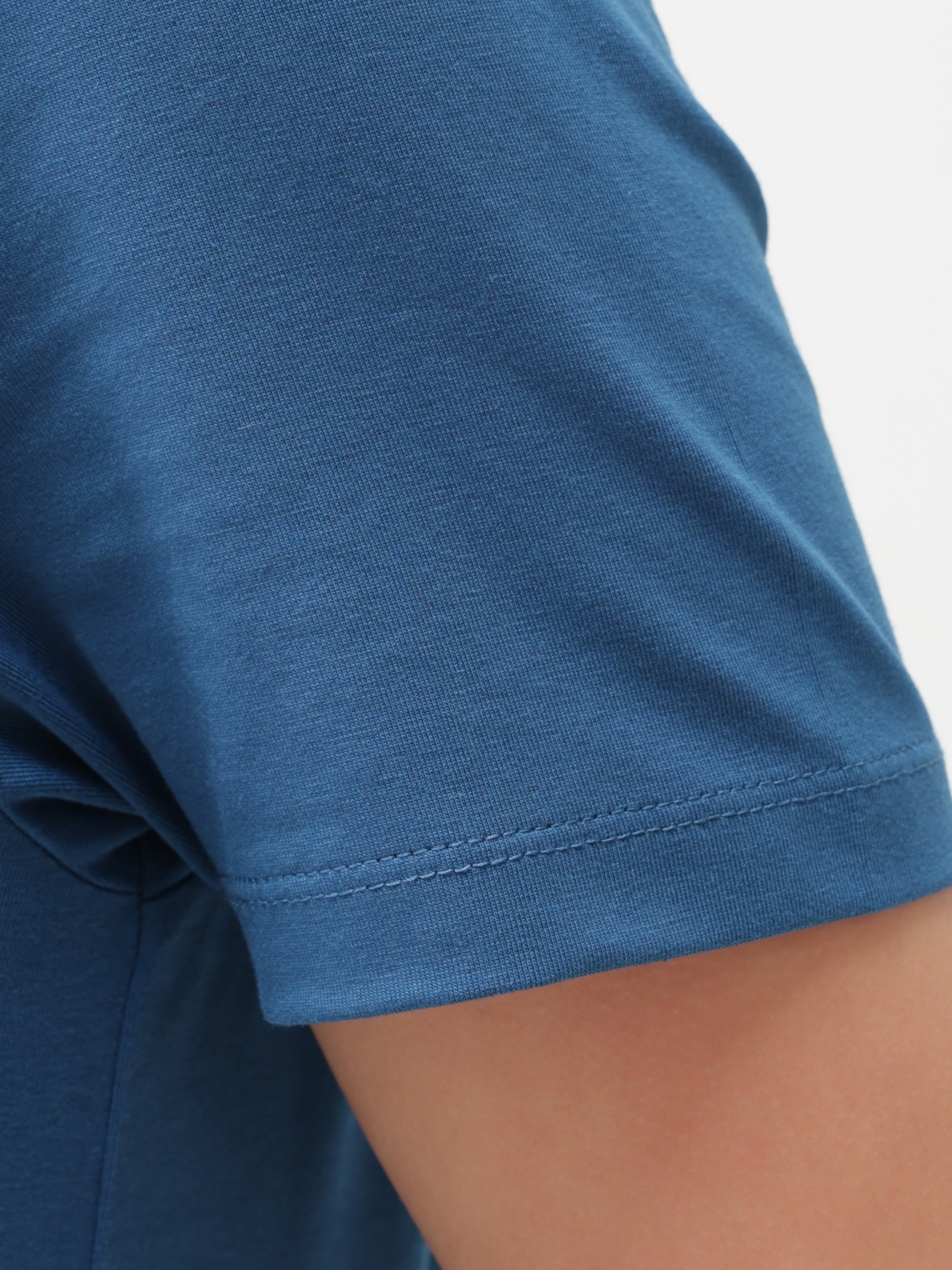 Close-up of sea blue Turms T-shirt sleeve, showcasing anti-stain, anti-odour, stretchable fabric with tailored fit and crew neckline.
