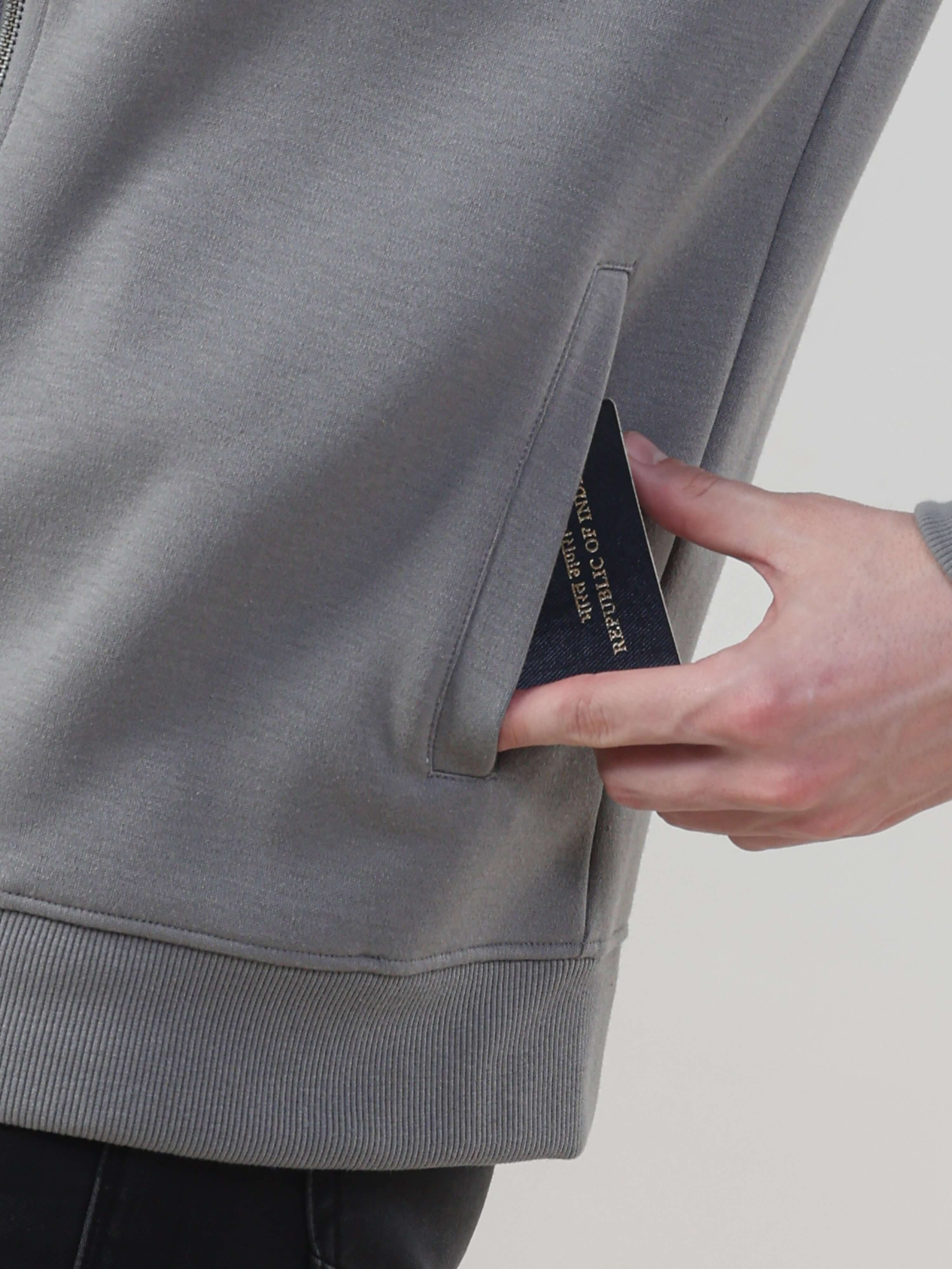 Close-up of a hand accessing the hidden pocket of the Turms Intelligent Traveller Jacket, showcasing its innovative design.