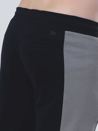 Close-up of men's joggers featuring black and grey color blocking with a stylish elastic waistband.