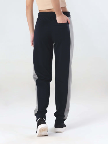 Back view of women in Turms Intelligent joggers, featuring anti-stain and waterproof fabric in stylish two-tone design.