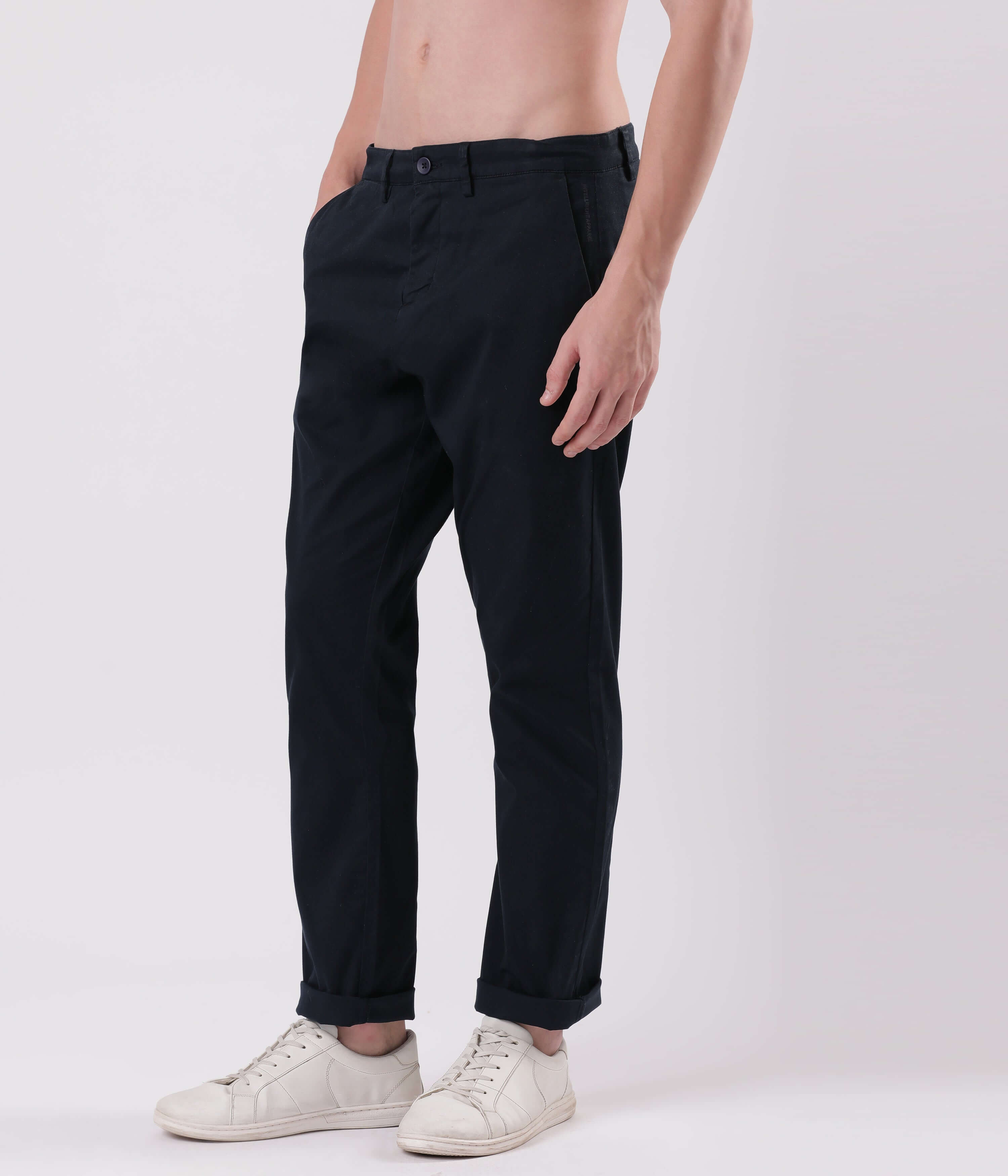 Model showcasing Turms Blue Eyed Chino pants in dark color with white sneakers, emphasizing style and comfort.