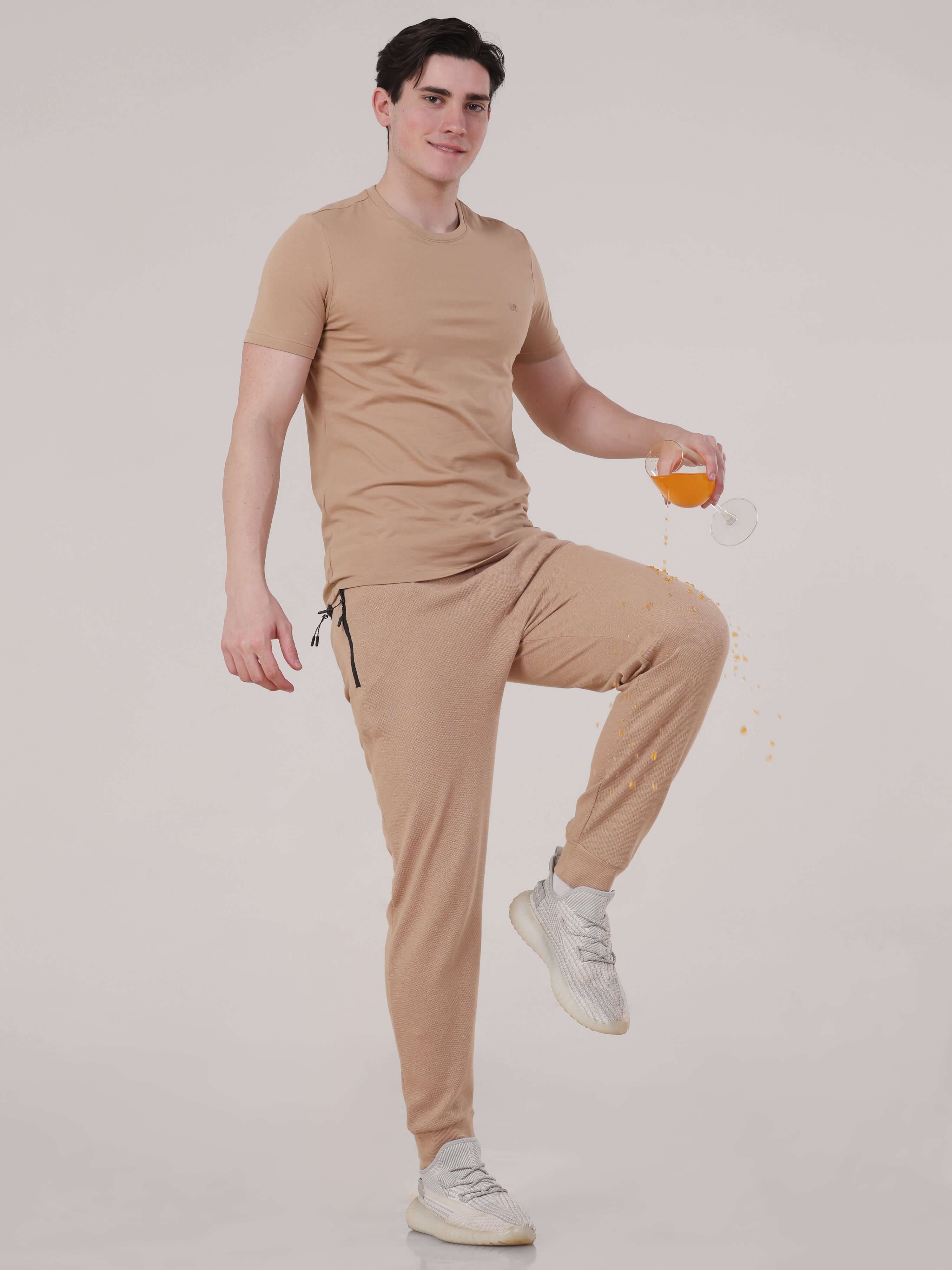 Man wearing Sahara Beige Turms Intelligent Jogger, highlighting waterproof, anti-stain features, ideal for travelers.