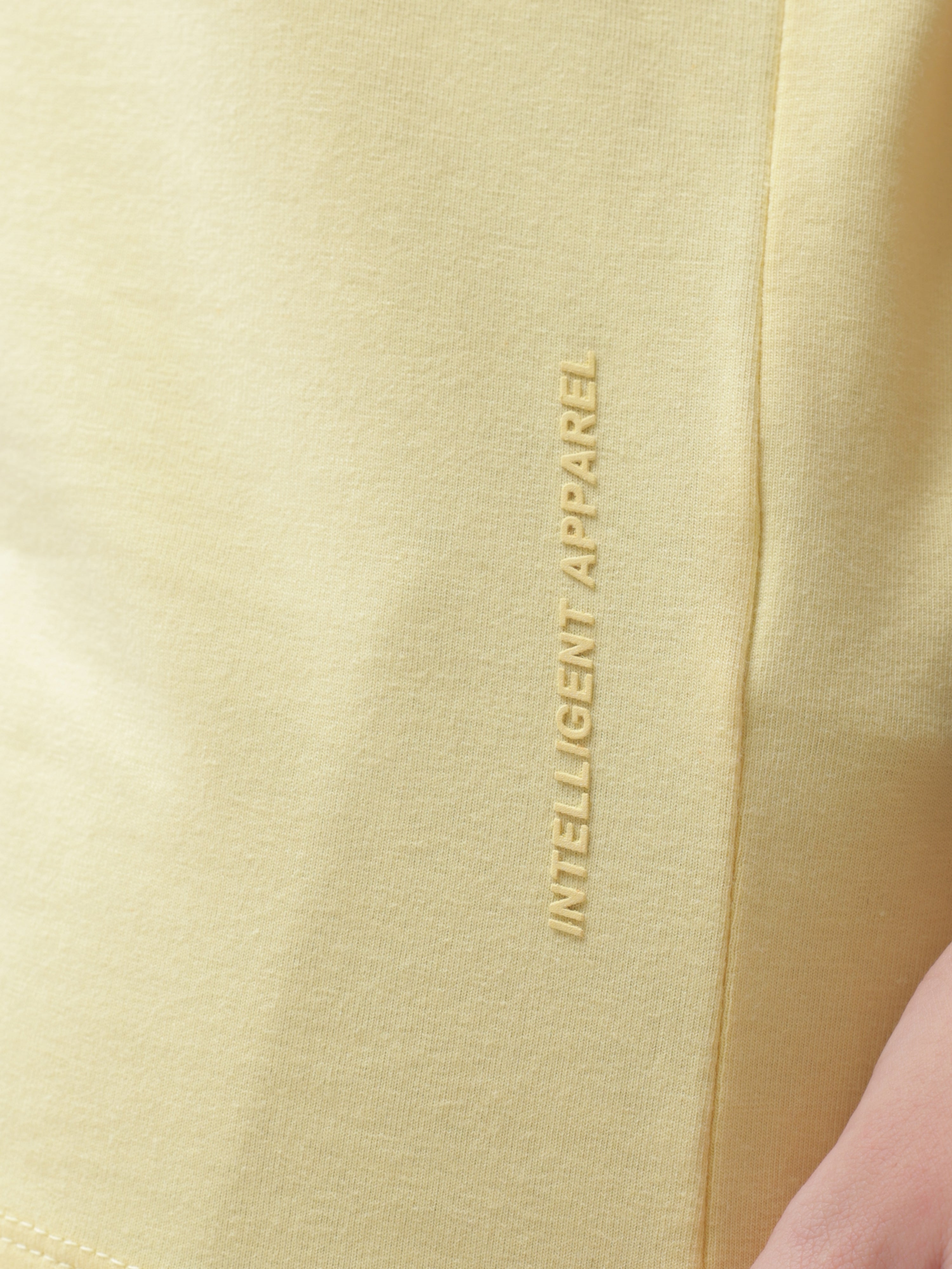 Stain-proof and odor-resistant yellow Turms T-shirt with "Intelligent Apparel" text on the side, showcasing premium cotton fabric.