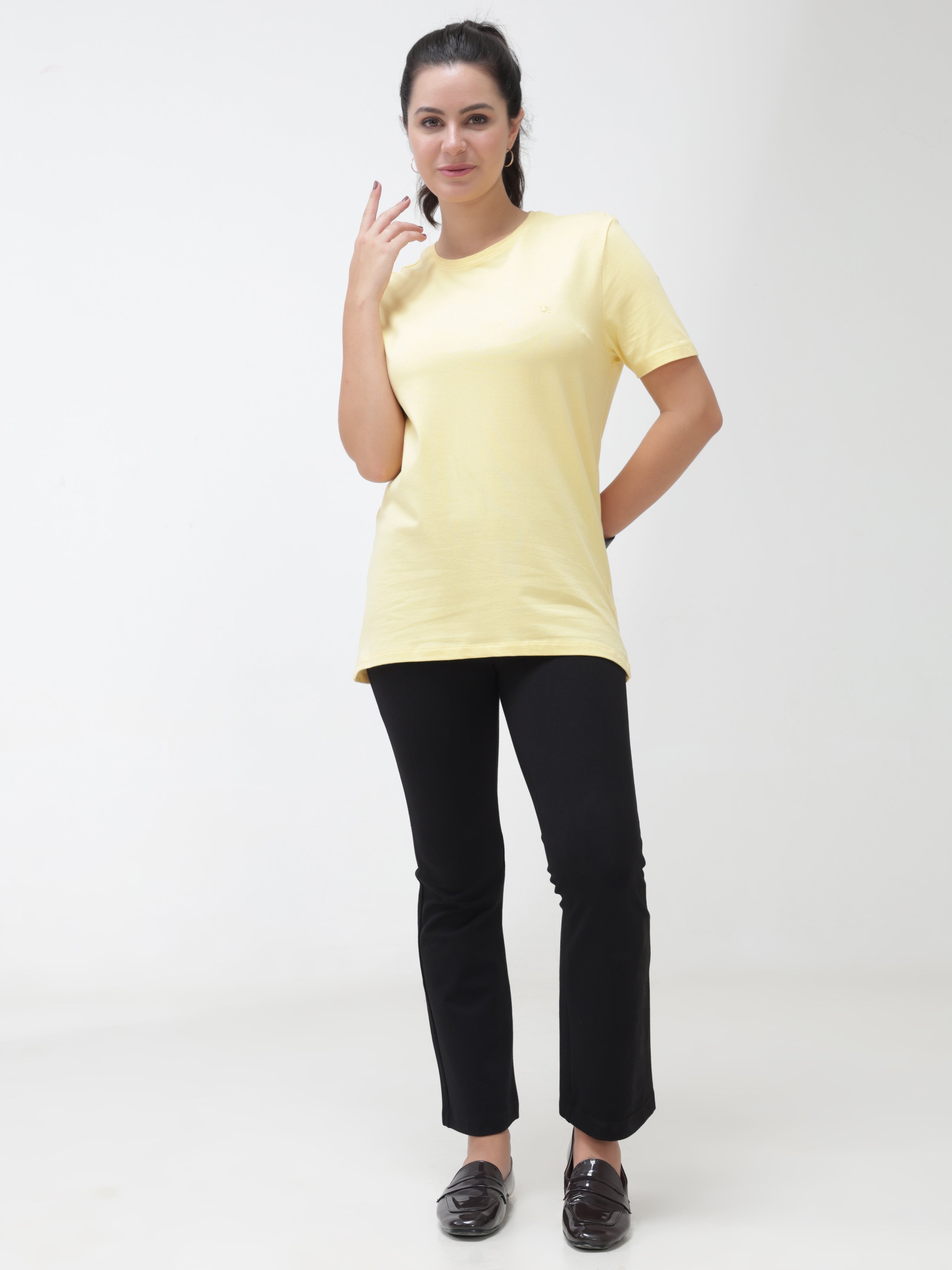 Stylish woman in yellow round-neck cotton T-shirt and black pants, showcasing casual wear and new shirt for men trends.
