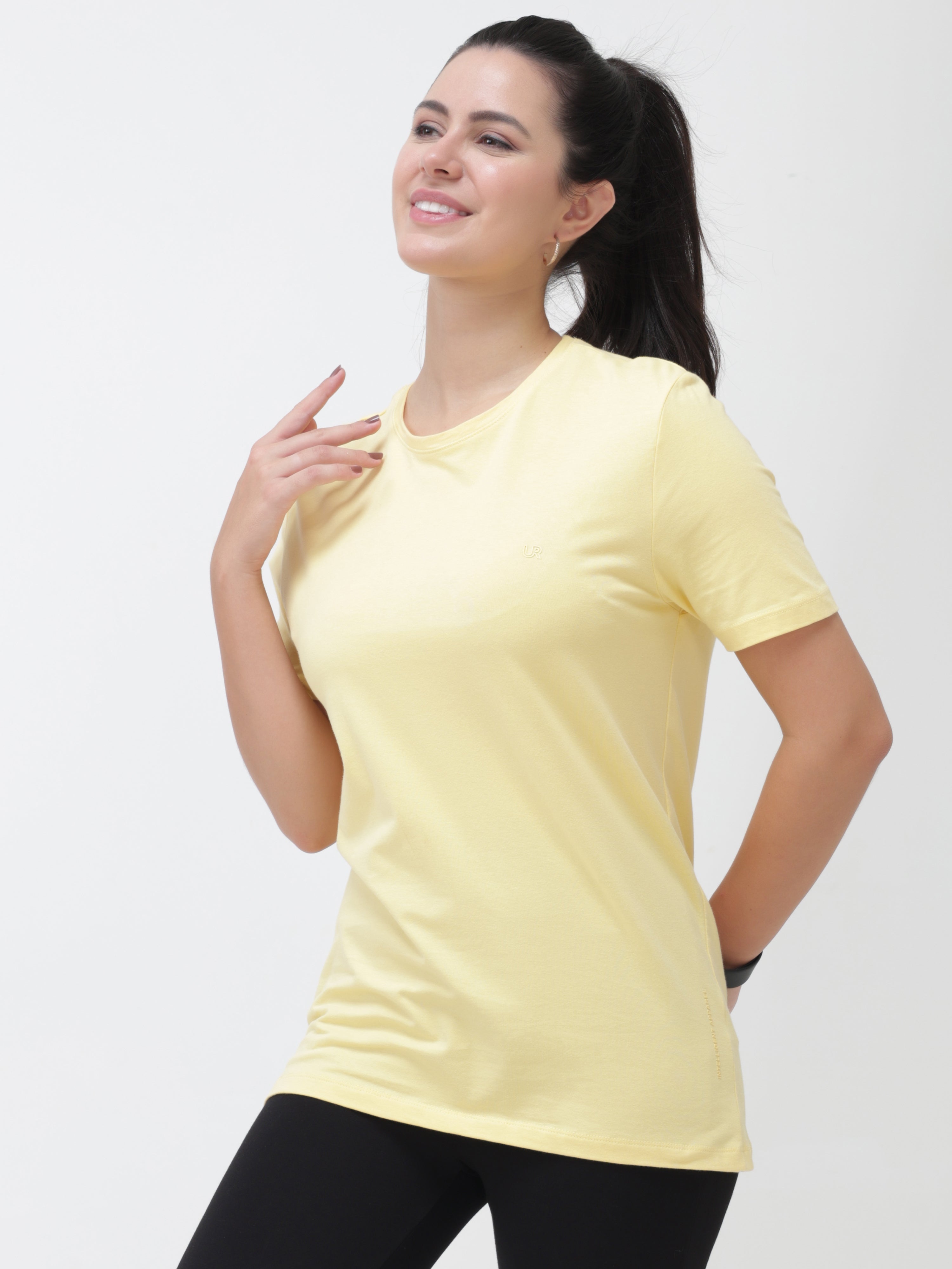 Woman wearing a yellow round-neck Turms T-shirt, showcasing stylish, stain-proof, and odor-resistant casual wear for women.