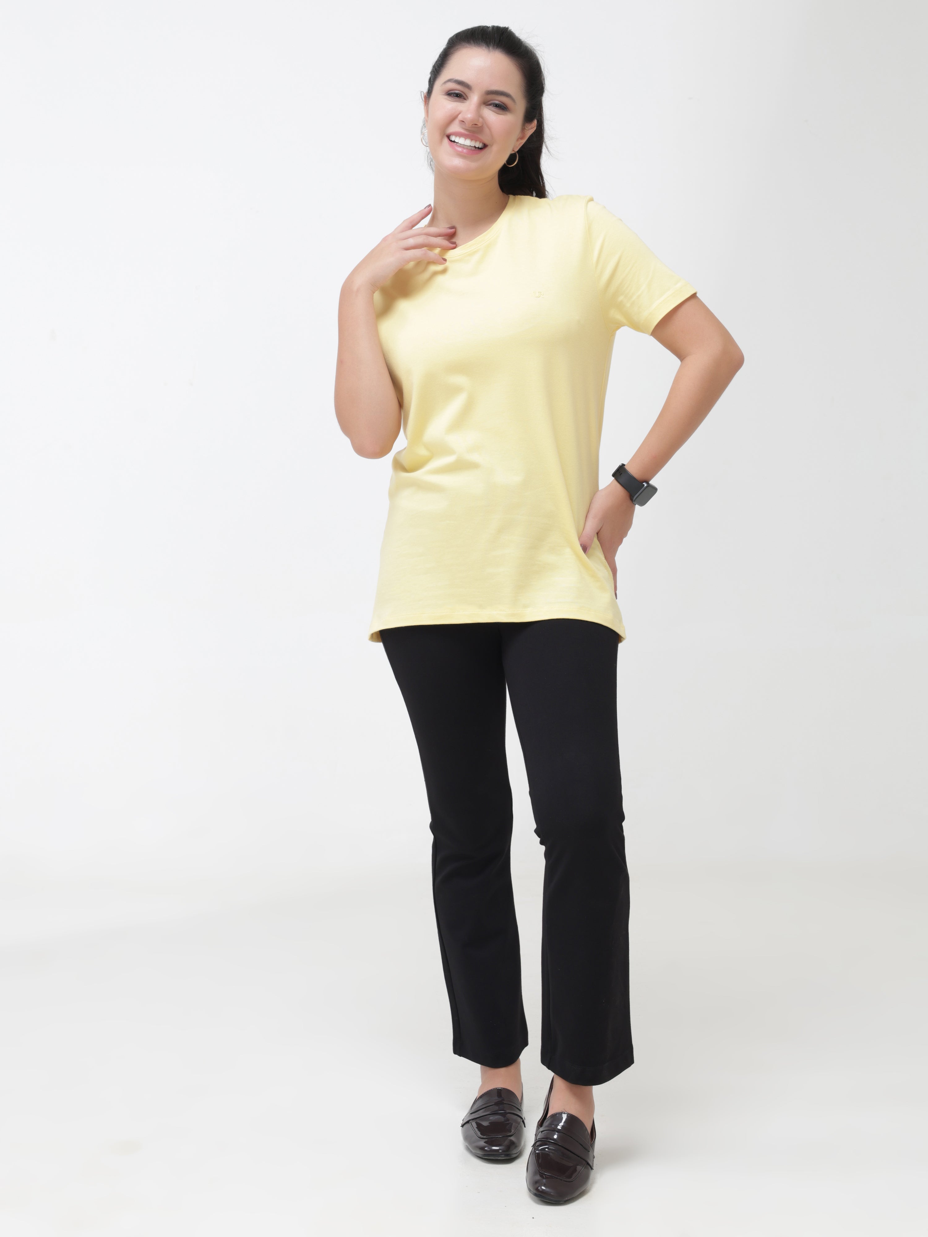 Woman wearing a yellow round-neck casual t-shirt, tailored fit with black trousers, showcasing stylish and premium casual wear for women.