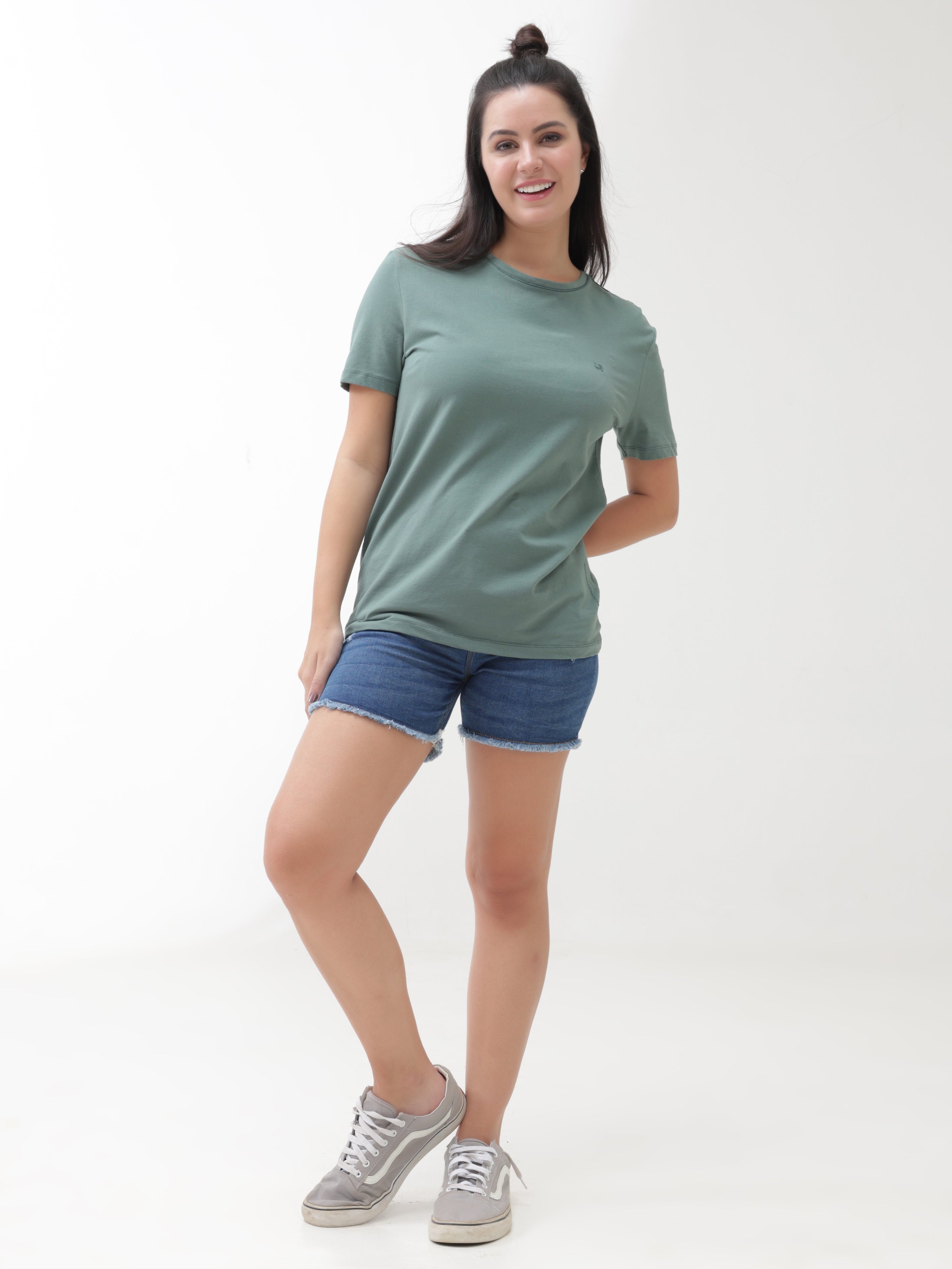 Woman wearing a Simple Green round-neck Turms T-shirt with denim shorts, showcasing stylish, stain-proof, and odor-resistant casual wear for women.