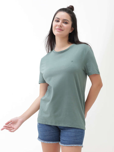 Woman wearing a Simple Green round-neck Turms T-shirt, stain-proof and odor-resistant, showcasing tailored fit and premium cotton blend fabric.