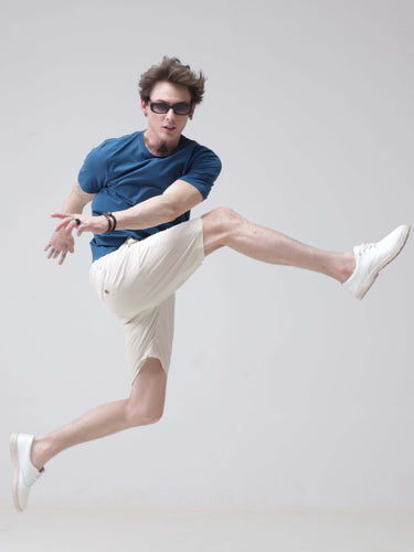 Man wearing Sea Blue stain-proof, odor-resistant round-neck Turms T-shirt performing a jump. Perfect for stylish, trending, and branded menswear.
