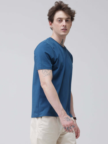 Man wearing a sea blue round neck t-shirt with tailored fit, showcasing branded, stylish, stain-proof, and odor-resistant t-shirts for men.