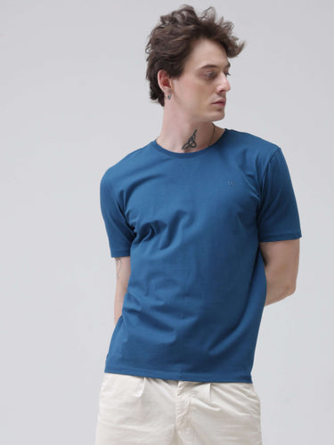 Man wearing sea blue round-neck t-shirt, tailored fit, stylish and stain-resistant, branded tshirts for men, trending tshirts for men.
