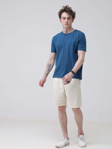 Man wearing Sea Blue round neck tshirt and white shorts stylish tshirts for men. Trending mens tshirts online, tailored fit branded tshirts for men.