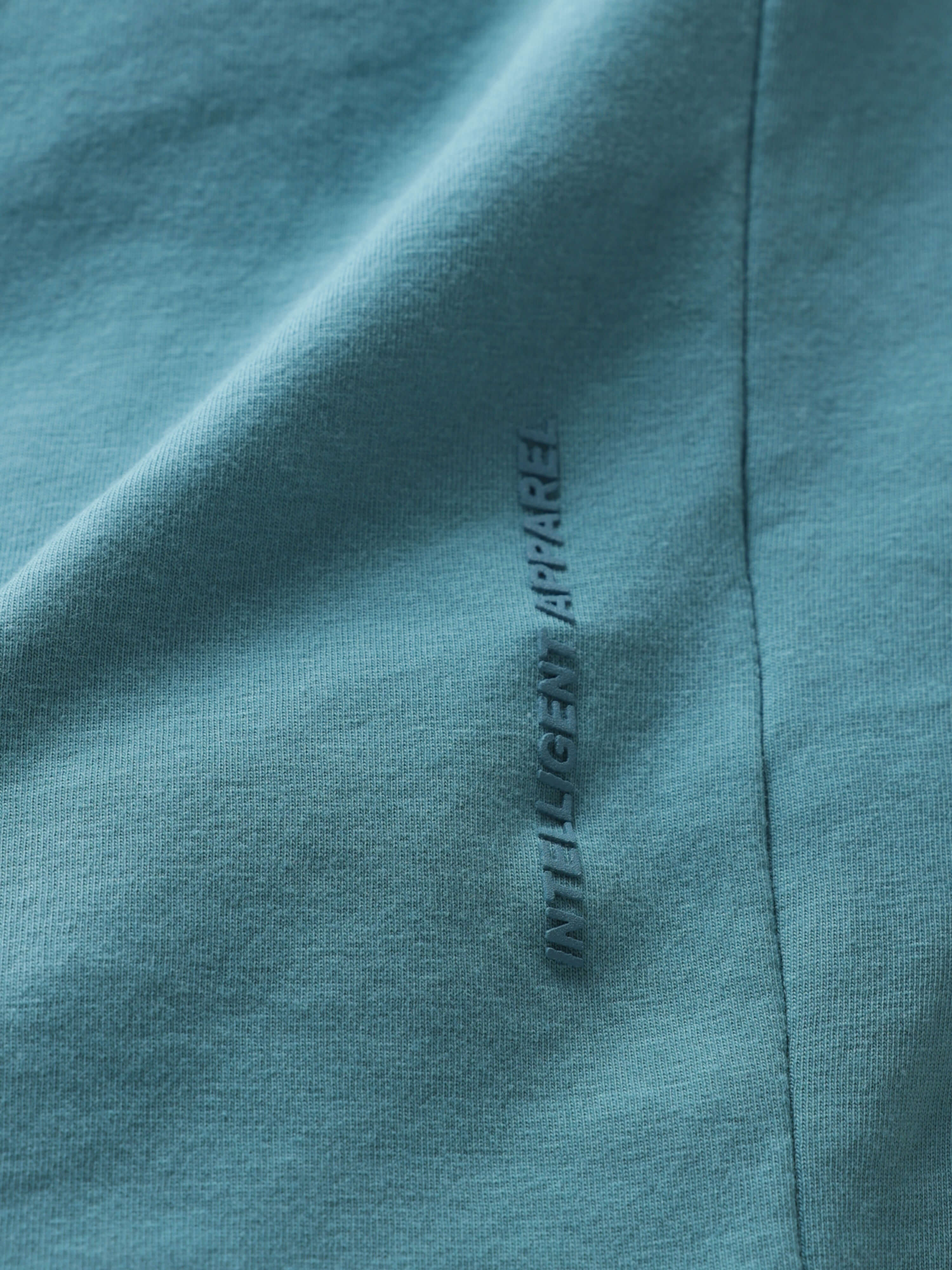 Close-up of Turms stain-proof and odor-resistant round-neck blue polo T-shirt fabric with Intelligent Apparel label