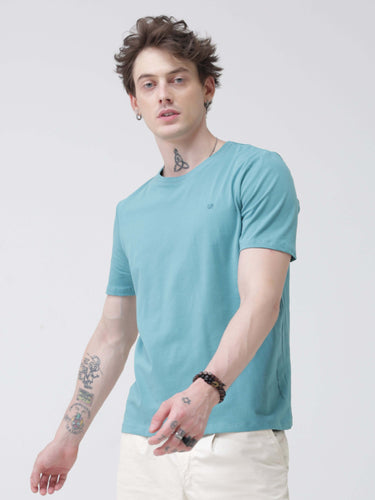 Man wearing a turquoise round-neck Turms T-shirt made from premium cotton, featuring a tailored fit and anti-stain, water-resistant technology.