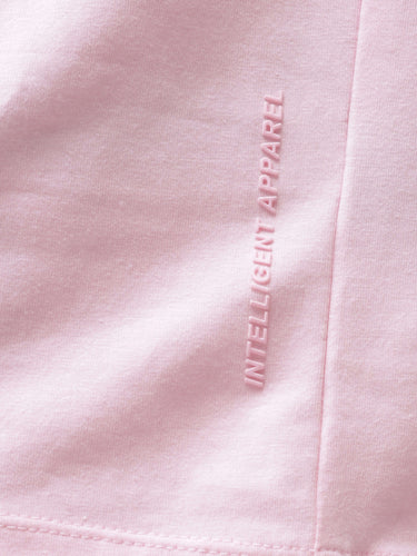 Close-up of pink Turms T-shirt with "Intelligent Apparel" text highlighting anti-stain, anti-odor, and stretchable fabric features.