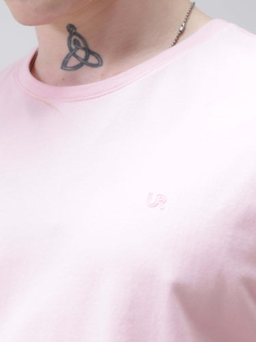 Close-up of a person wearing a pink Mystic Orchid Turms T-shirt with a round neck, displaying a tattoo and necklace, showcasing anti-stain and anti-odor features.