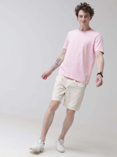 Man wearing a pink round-neck Turms T-shirt and beige shorts, showcasing the anti-stain, anti-odour, and stretchable intelligent apparel.