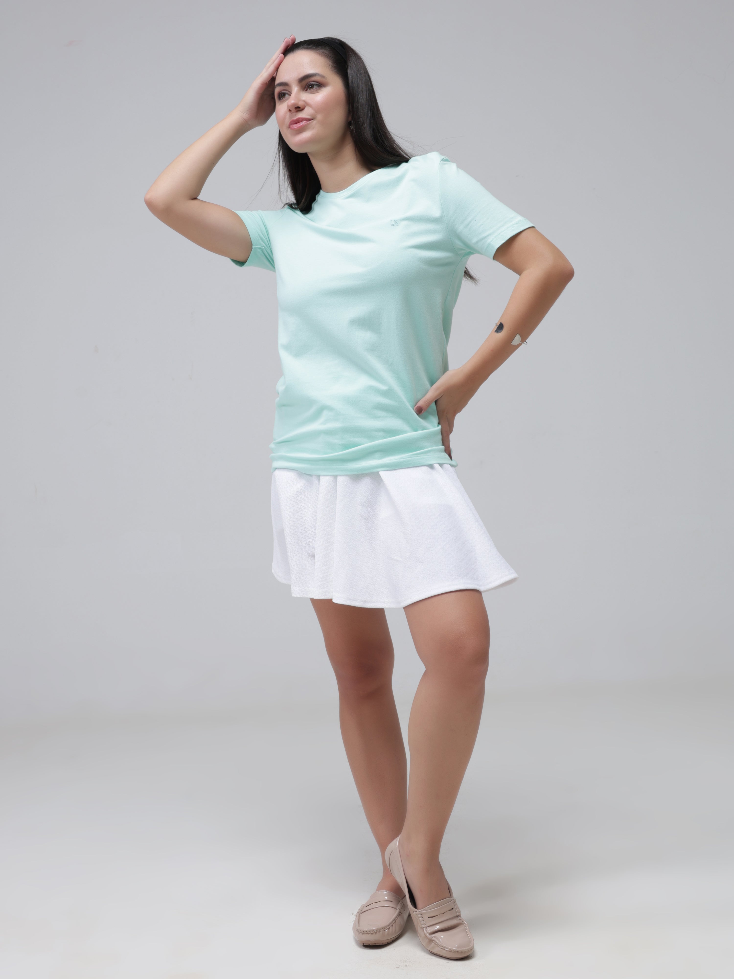 Woman wearing Aqua stain-proof and odor-resistant round-neck Turms T-shirt paired with white casual skirt and beige shoes.