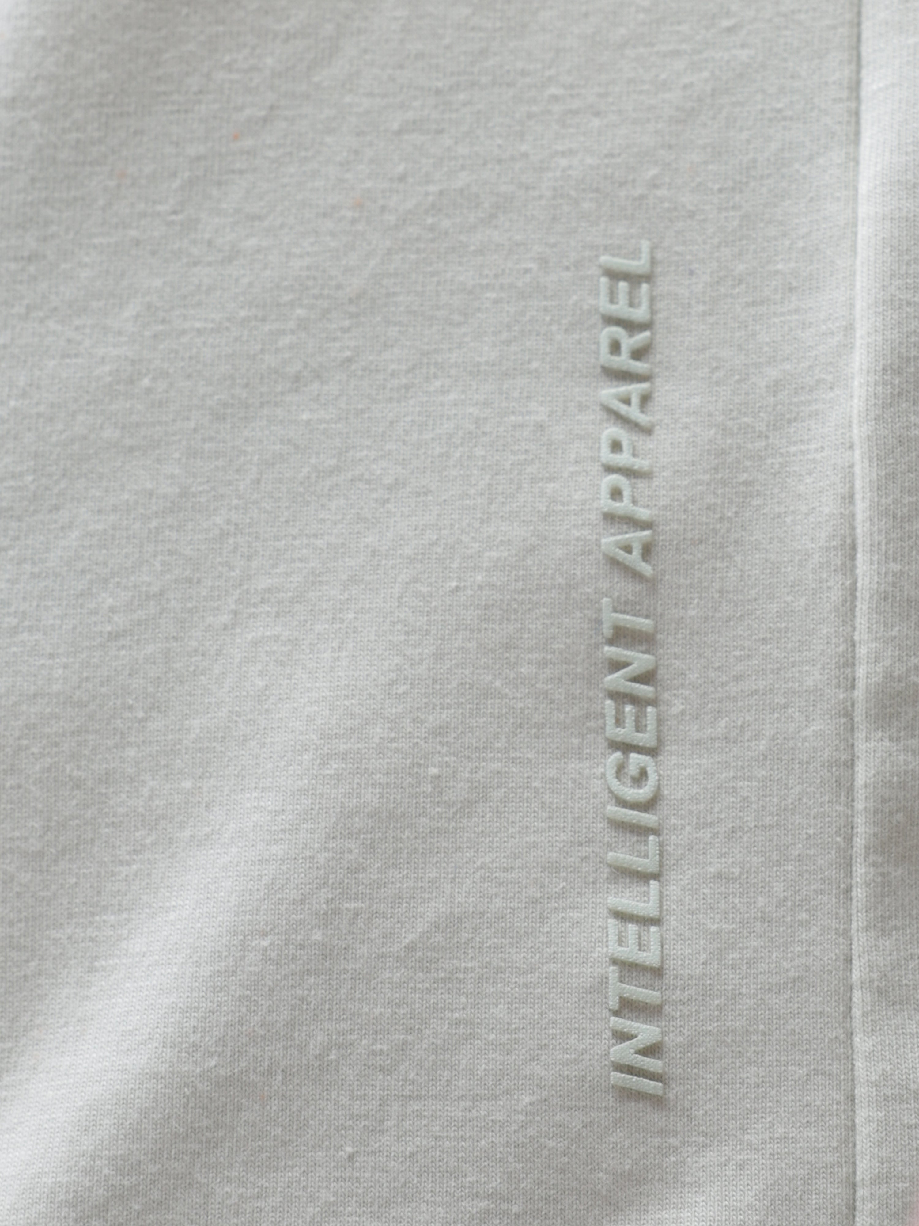 Close-up of Lime Enigma Turms T-shirt showcasing "Intelligent Apparel" text on fabric. Anti-stain, anti-odour, stretchable, trending.