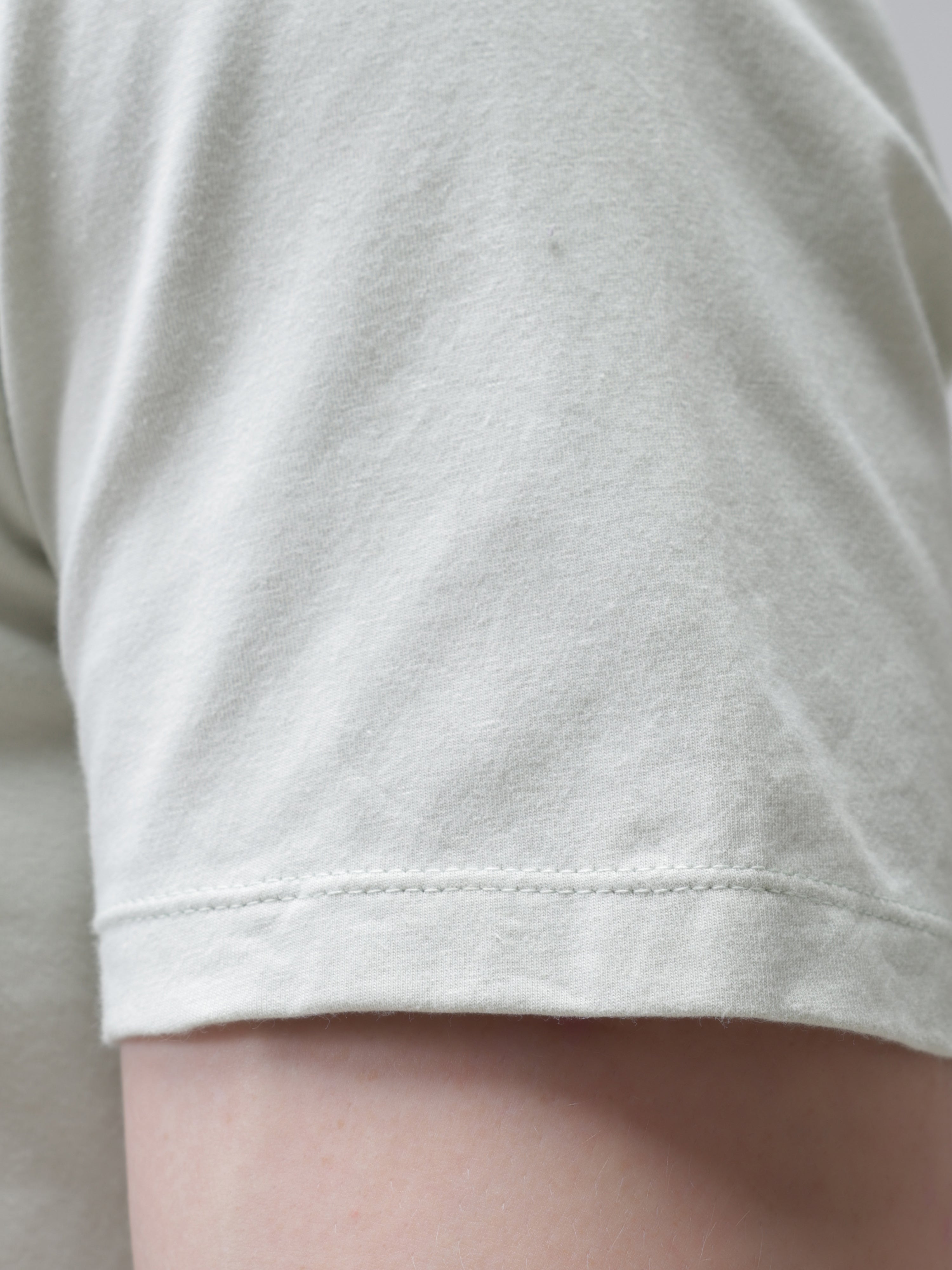 Close-up of sleeve on Lime Enigma Turms T-shirt, showcasing its anti-stain, anti-odour, and stretchable premium cotton fabric.