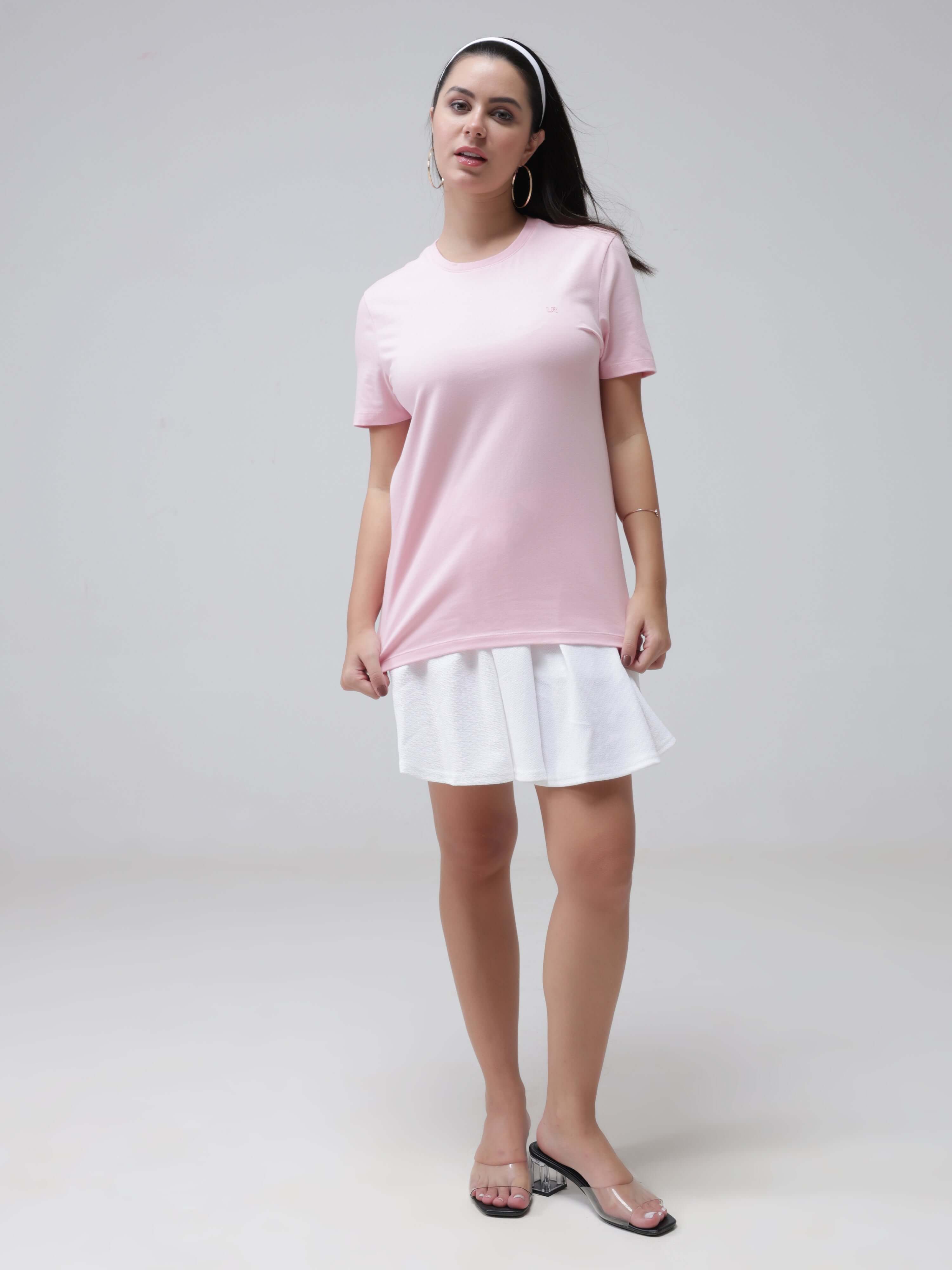 Woman wearing pink round-neck Turms T-shirt and white skirt, showcase of anti-stain, anti-odour intelligent apparel, tailored fit, stretchable fabric.