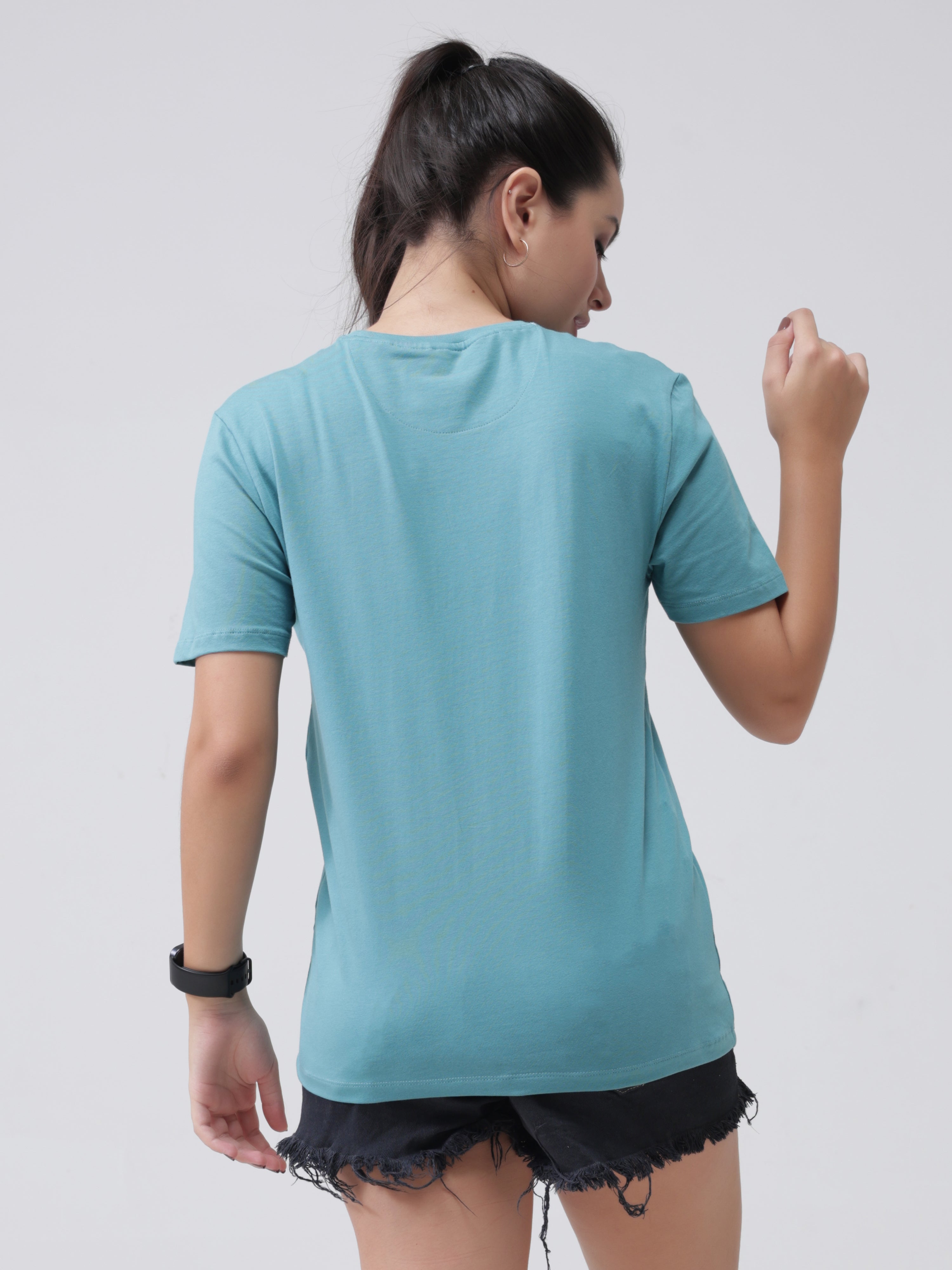 Woman wearing a blue round-neck Turms T-shirt and black shorts, showcasing the back view.