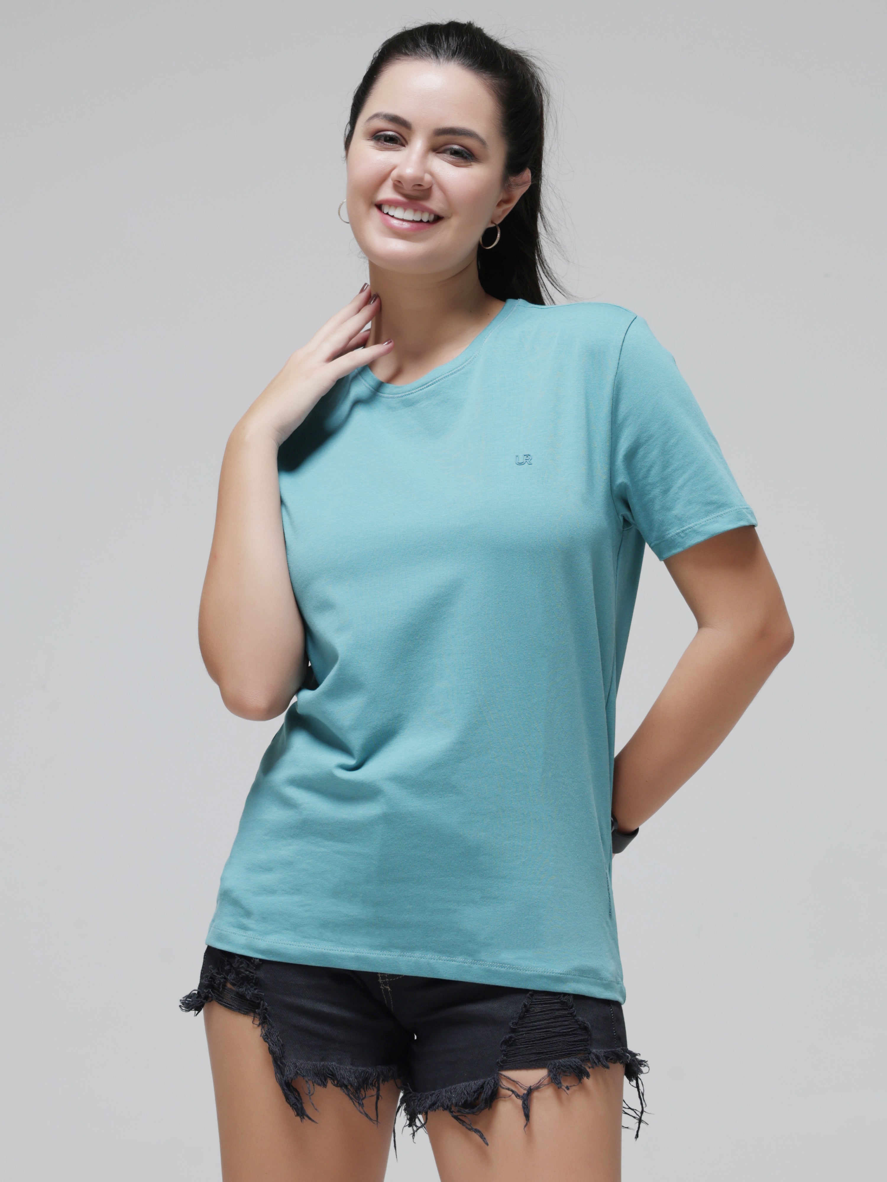Stylish woman wearing a Turms stain-proof and odor-resistant round-neck T-shirt, color blue, paired with black denim shorts.