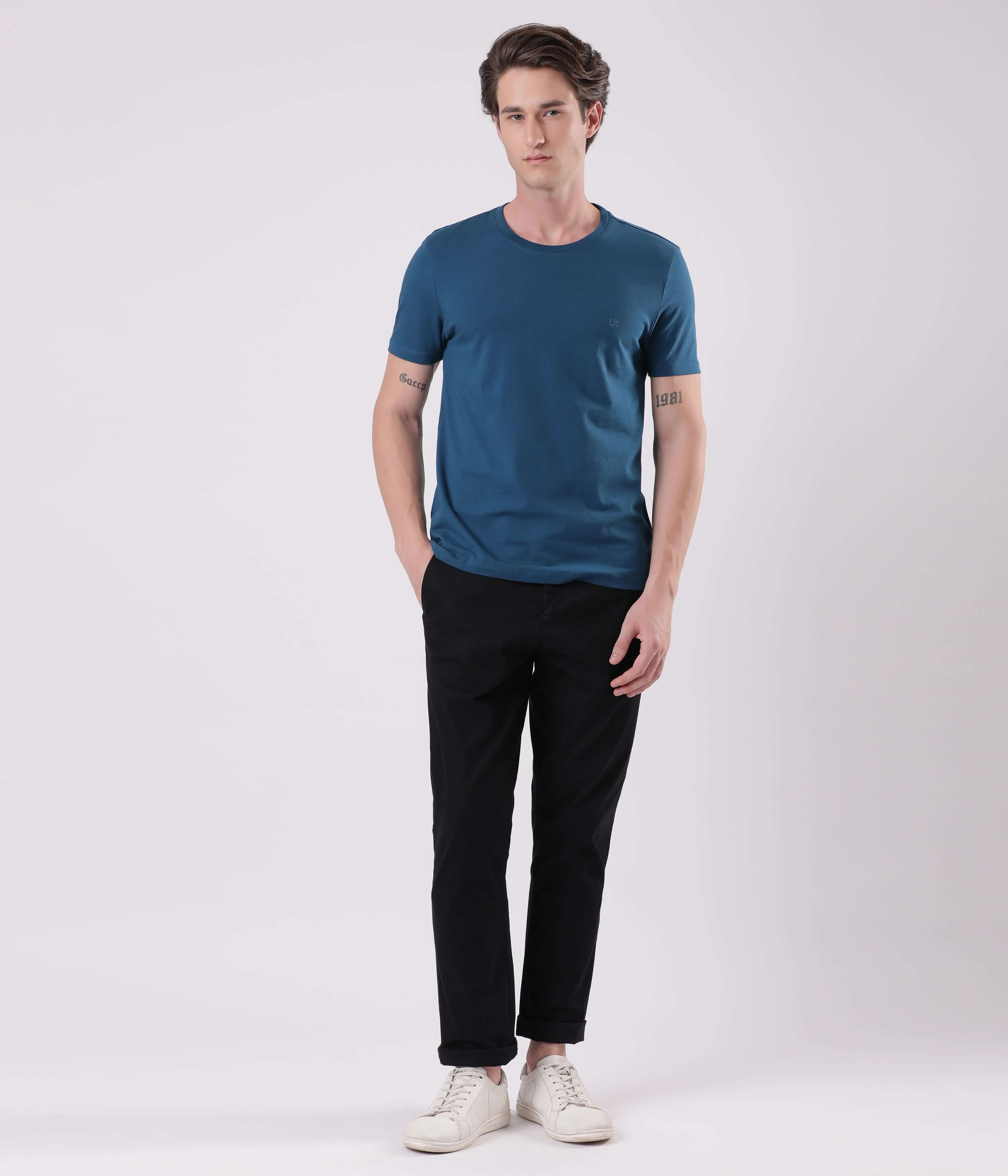 Model wearing Turms Black Sea smart flex Chino with a blue t-shirt and white sneakers.