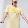 Woman wearing stain-resistant round neck yellow Turms T-shirt, enjoying spill resistance, promoting stylish, premium cotton casual wear for men and women.