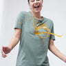 Woman smiling while liquid spills on her Simple Green stain-repellent and odor-resistant round-neck Turms T-shirt.