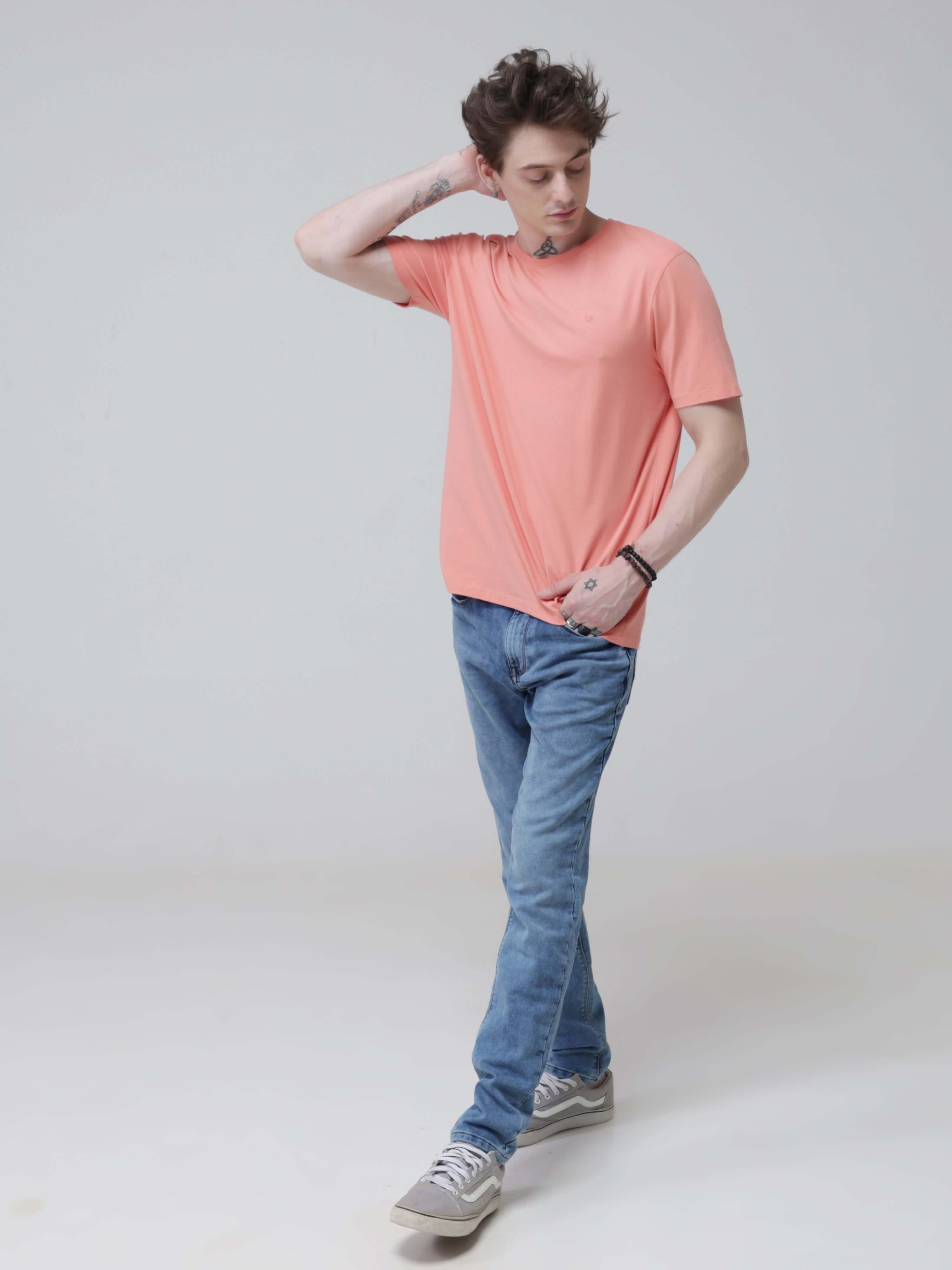 Man wearing Sunset Spice round-neck Turms T-shirt and blue jeans, demonstrating the anti-stain, anti-odour, and stretchable features of the intelligent apparel.