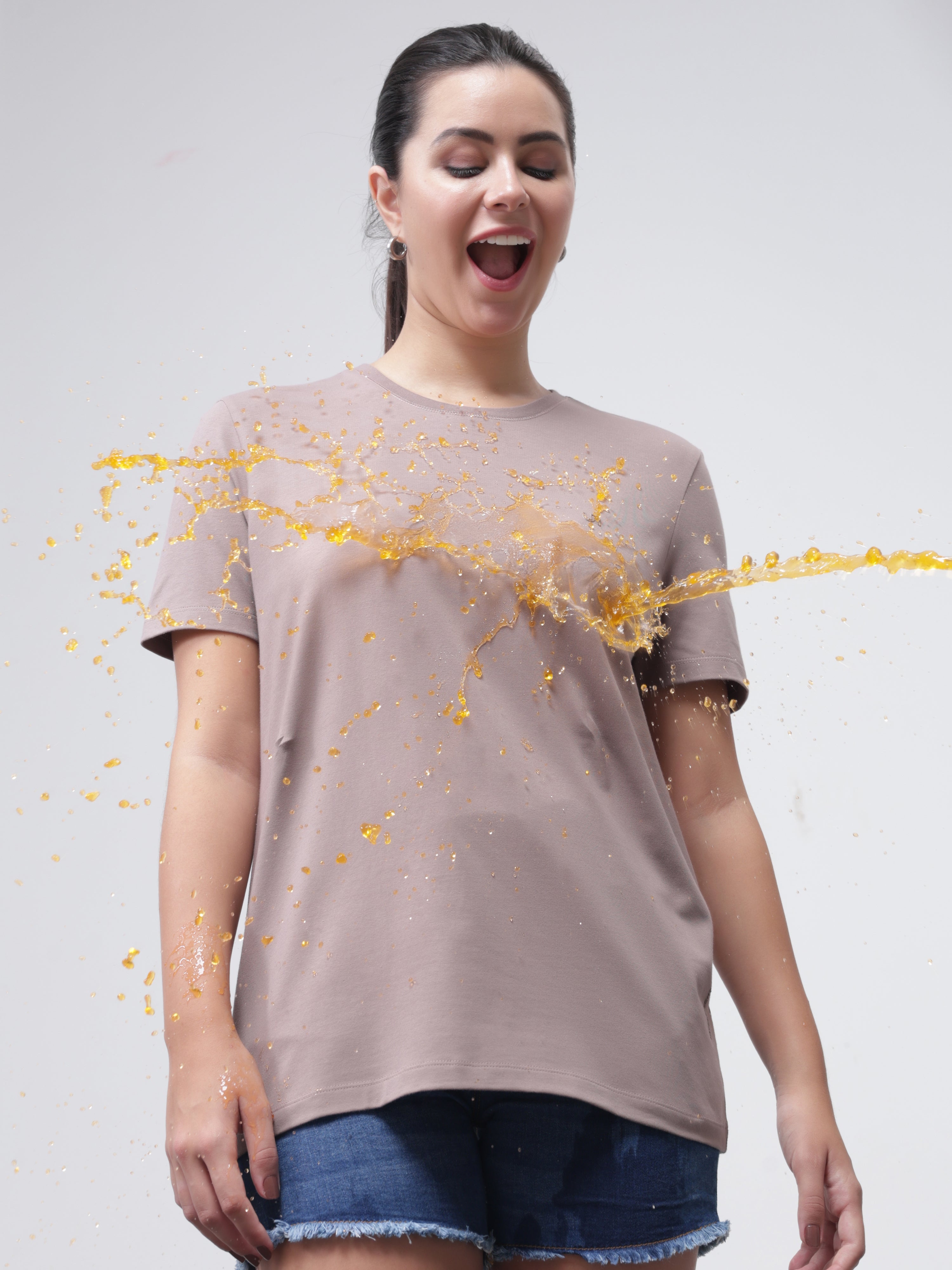 Woman wearing a Dusky Maroon stain-proof, anti-odor, stretchable Turms T-shirt with tailored fit, repelling liquid stains with ease.