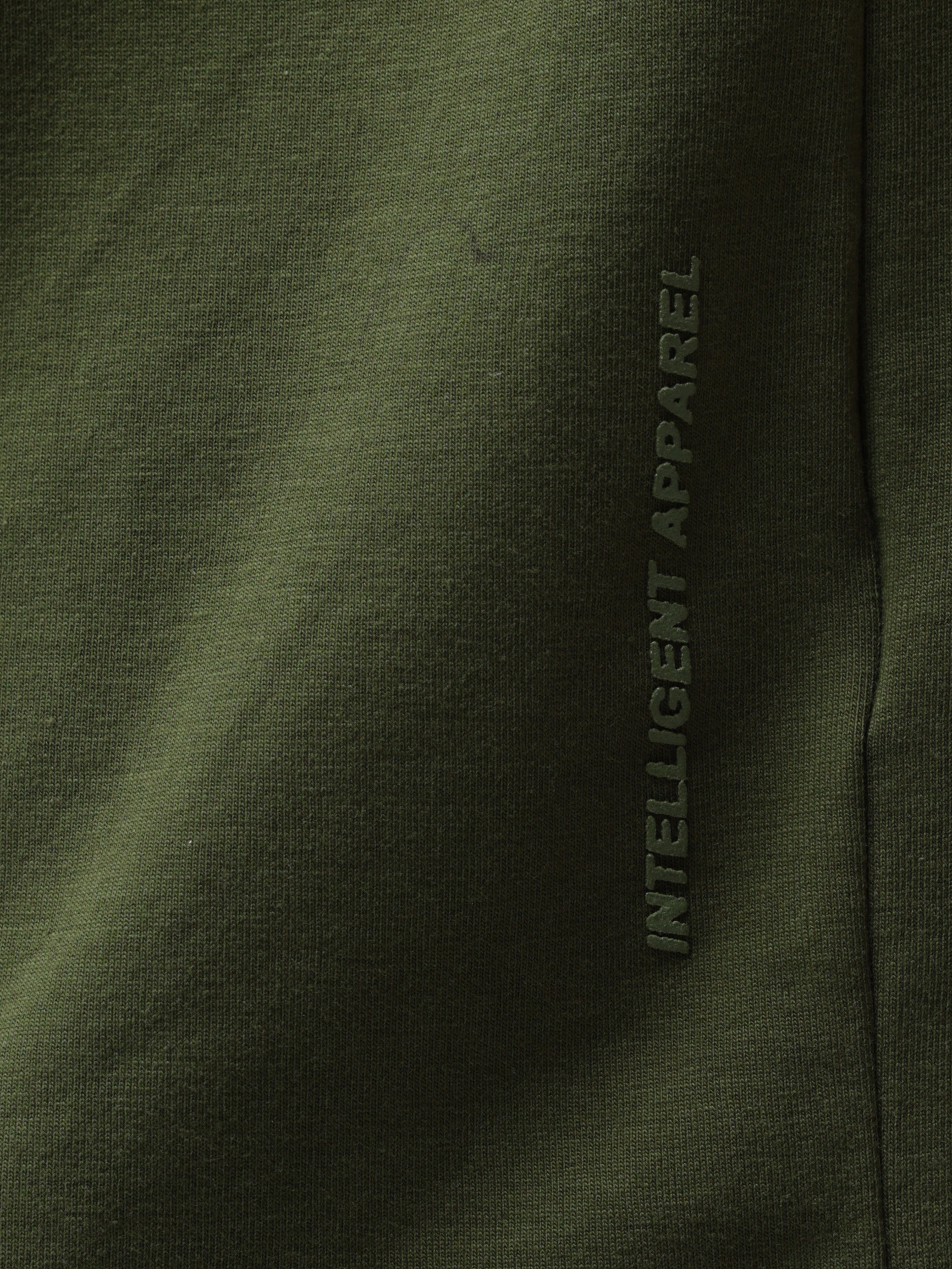 Olive green Turms round-neck T-shirt showcasing "Intelligent Apparel" detail, stain-proof, water-resistant, premium cotton blend fabric.