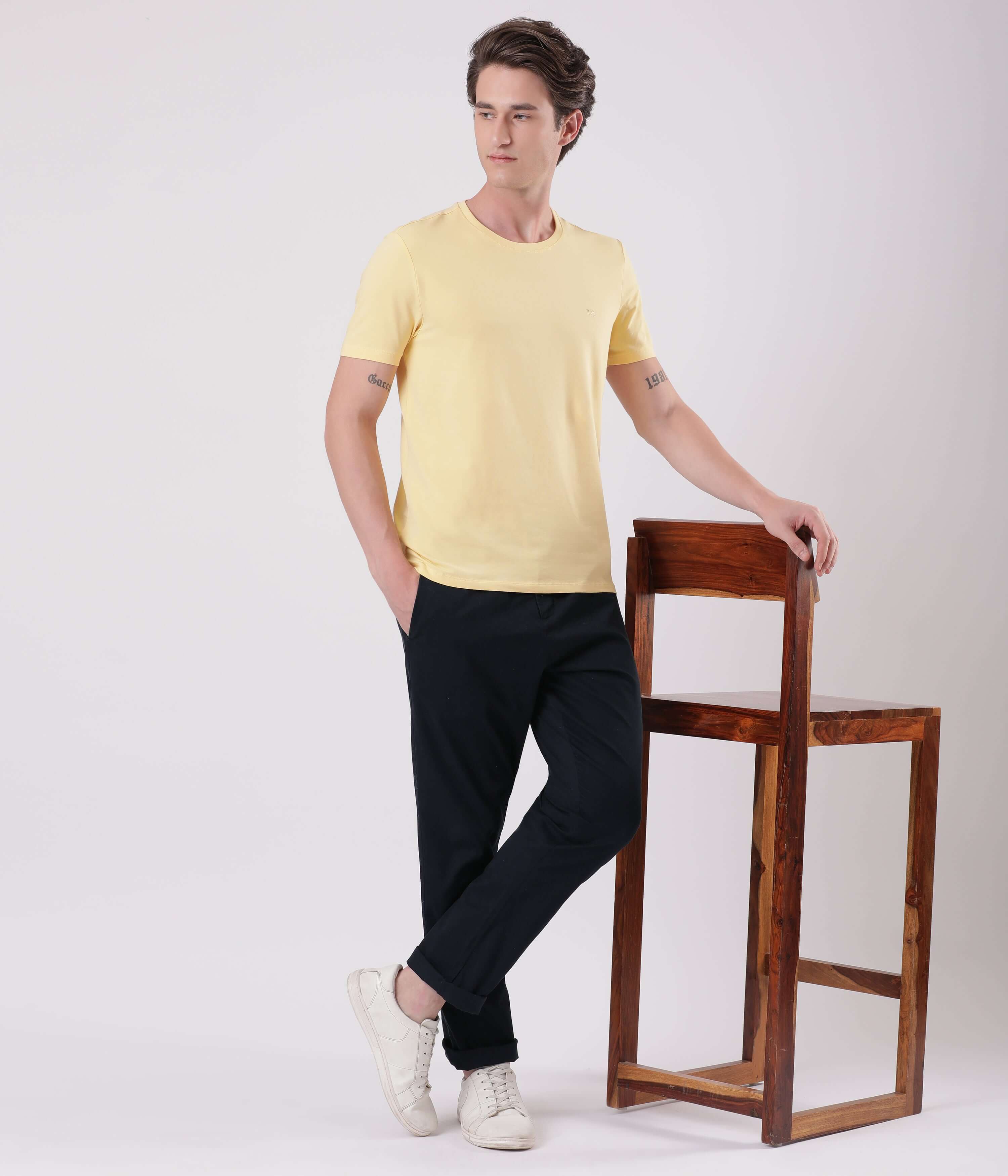 Model wearing a yellow t-shirt and navy chinos, showcasing the Turms Blue Eyed style with a modern casual look.