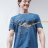Man wearing stain-proof blue round neck t-shirt with liquid repelling off. Stylish branded t-shirt for men. Trending, new, best mens tshirts online.