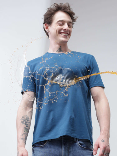 Man wearing stain-proof blue round neck t-shirt with liquid repelling off. Stylish branded t-shirt for men. Trending, new, best mens tshirts online.