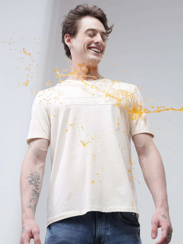 Model smiling while water-based stain repels off Soft Peach Turms T-shirt; anti-stain, anti-odor, stretchable intelligent apparel.