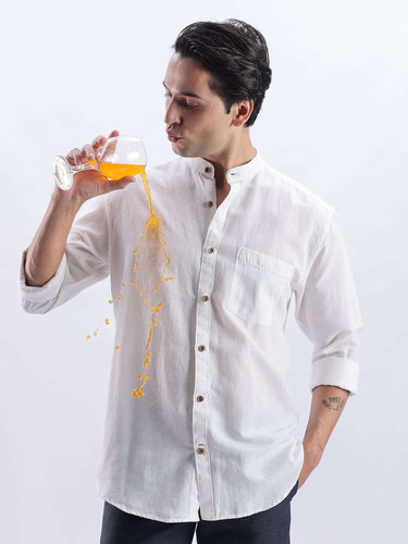 Model wearing White Wolf 2.0 linen shirt, showcasing its anti-stain feature while enjoying a drink.