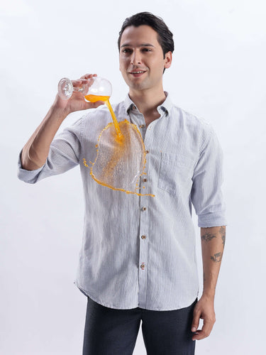 Man wearing Skyline Blue shirt demonstrating anti stain feature while pouring juice.