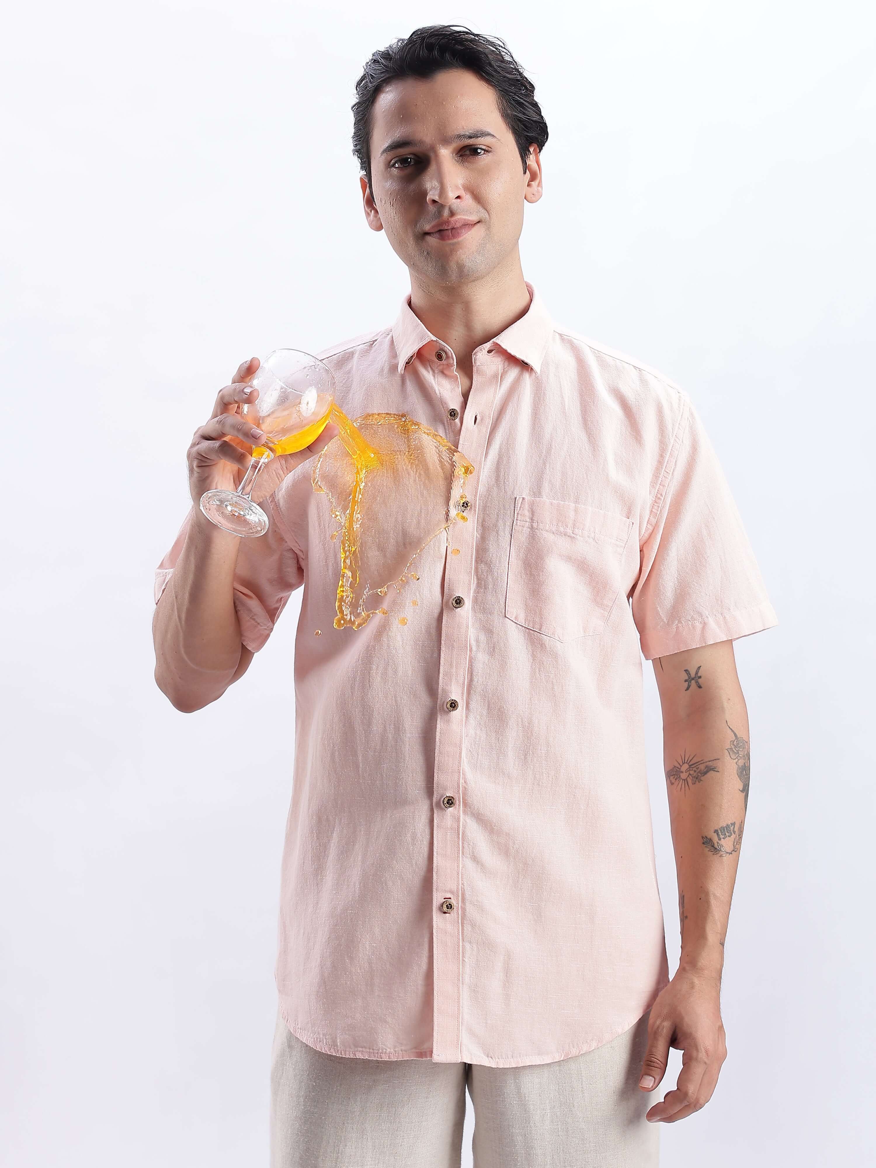 Man wearing a blushy peach linen shirt from Turms Intelligent Apparel, showcasing its anti-stain, water-proof features.