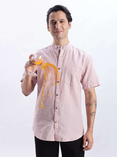 A man wearing a Rusty Petal linen shirt from Turms Intelligent Apparel, demonstrating anti-stain properties with spilled drink.