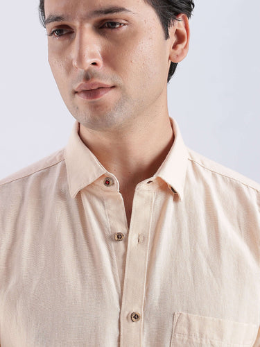 Close-up of a man wearing an Opalescent Sand linen shirt from Turms Intelligent Apparel, showcasing its stylish design.