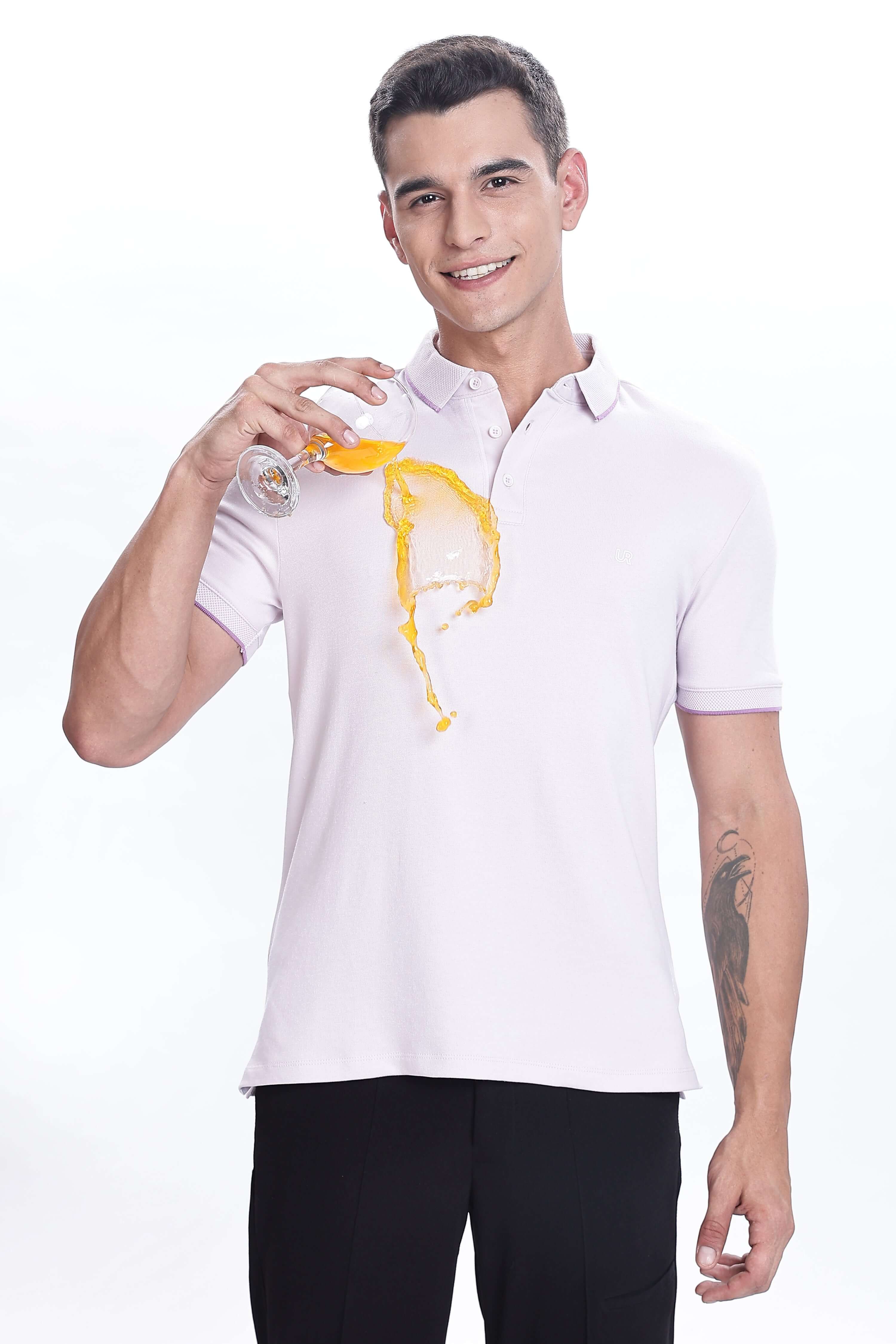 Man wearing Lavender Fires premium cotton polo, pouring juice, showcasing anti-stain and water-proof features.