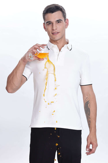Man wearing White Owl cotton polo tshirt, showcasing premium water proof, anti-stain features while spilling juice.