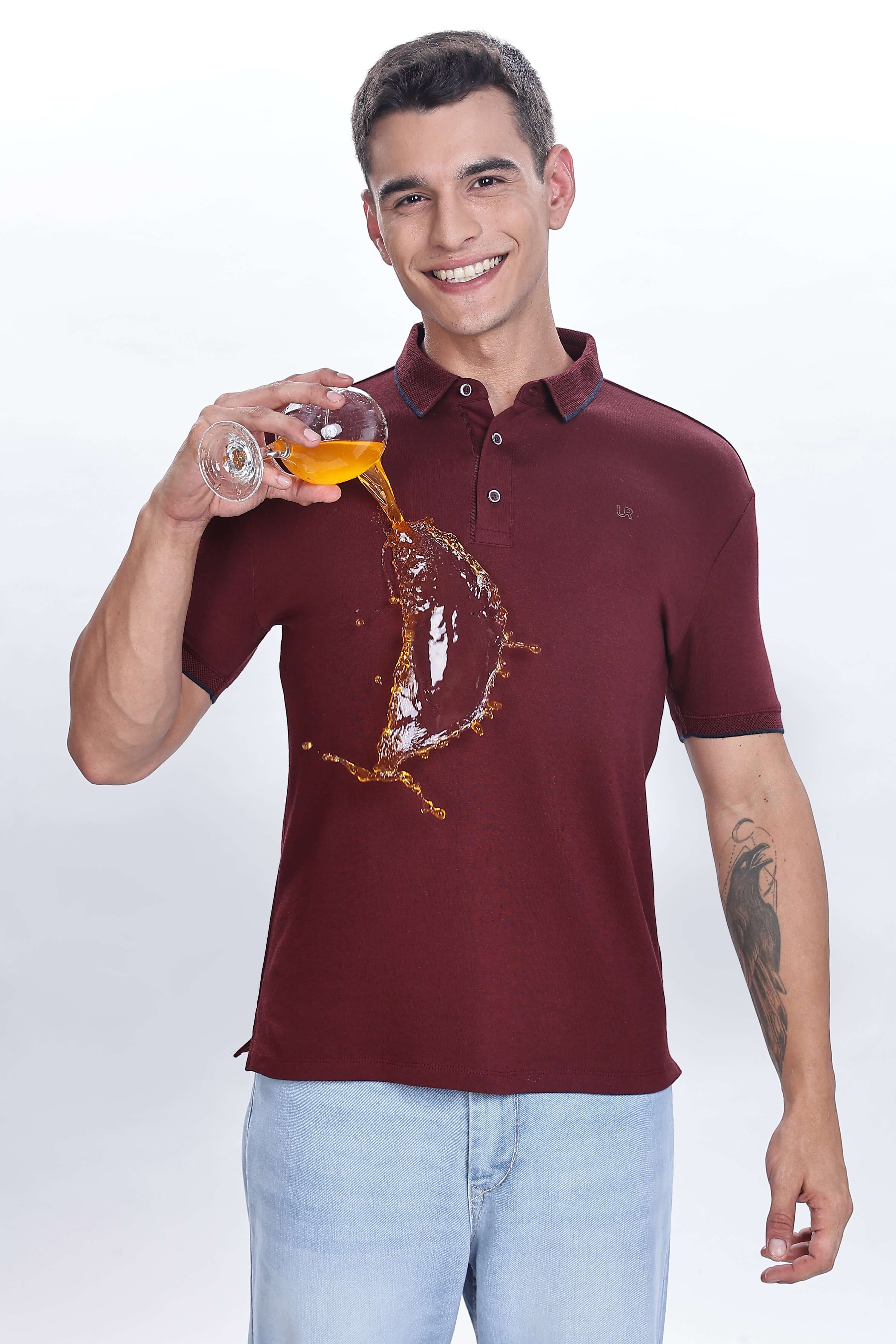 Man wearing a Country Wine cotton polo tshirt, demonstrating its waterproof and antistain properties while pouring a drink.