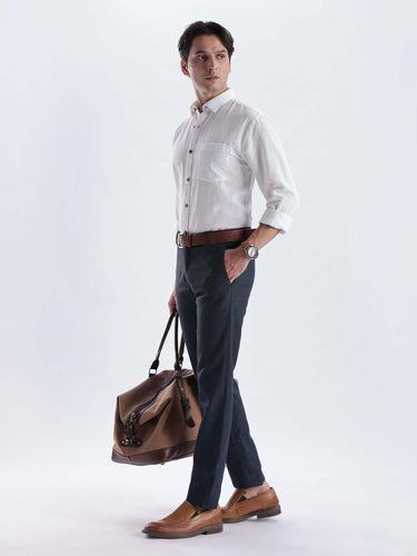 White Elephant: Model wearing a stylish white linen shirt with trousers and a brown bag, showcasing everyday luxury.